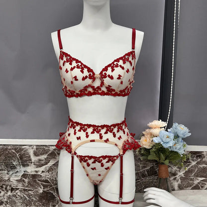 This is a delicate red heart embroidered lingerie set, featuring a sheer bra, thong, and garter belt, all with matching red straps and trim, displayed on a mannequin.