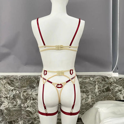 A beige and dark red lingerie set on a mannequin, featuring a bra, thong, and garter straps. The thong and garters are adorned with distinctive red lip motifs.